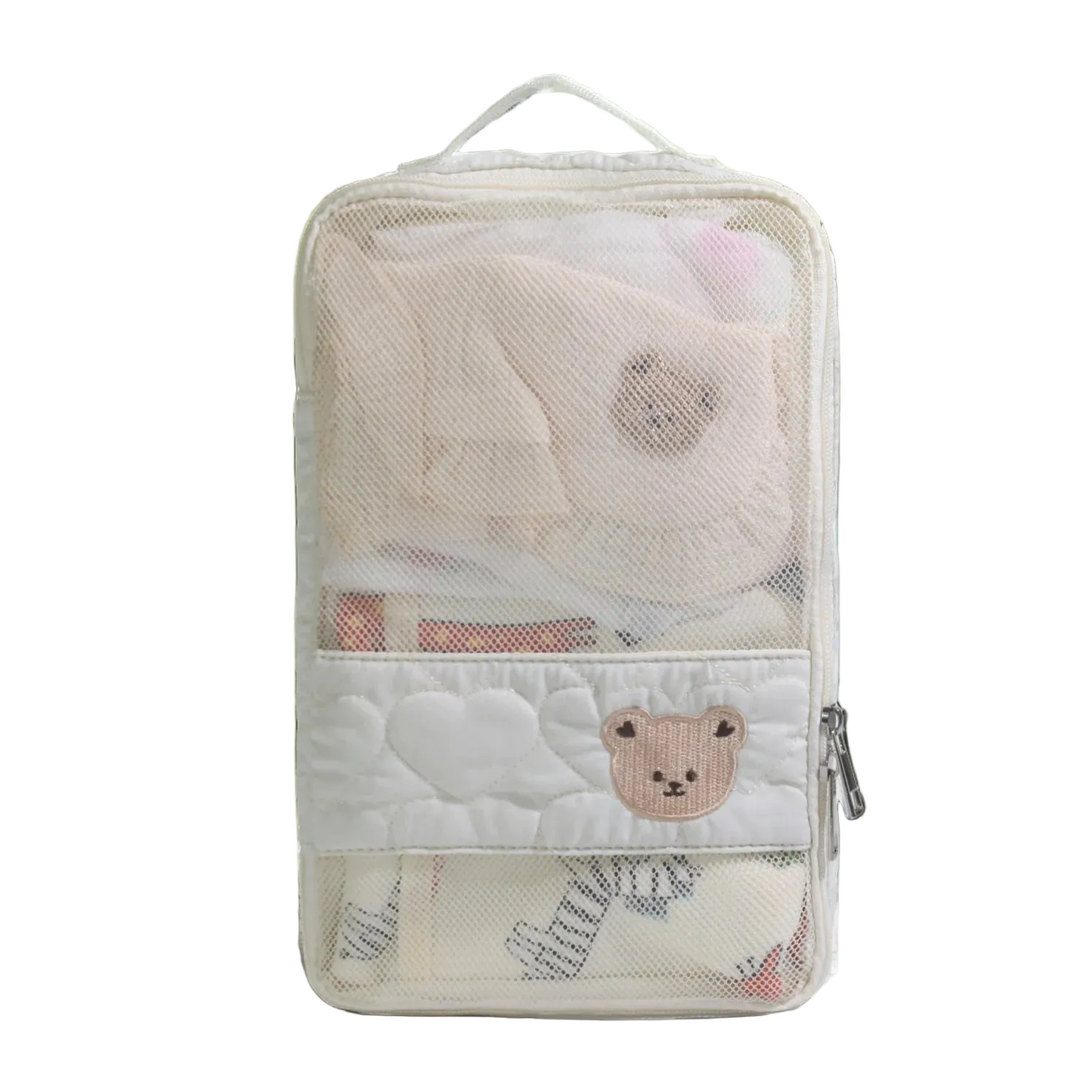 Transparent travel pouch with cartoon bear design on a light surface with greenery.